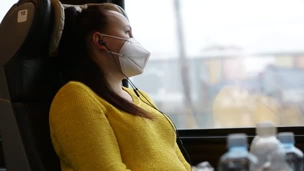 Hezká mladá brunetka s obličejovou maskou nebo respirátor cestování vlakem během covid-19 pandemie, pobyt v bezpečí cestování — Stock video