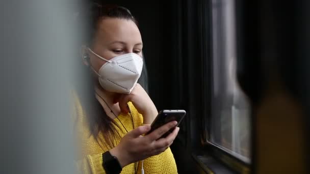 Mujer morena bastante joven con mascarilla facial o respirador viajando en el tren durante la pandemia de covid-19, mantenerse a salvo viajar — Vídeos de Stock