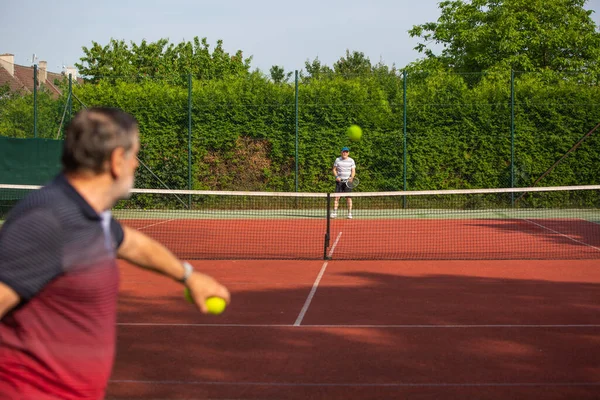 Pensionärer som spelar tennis, pensionärer som njuter av fritid tennis utanför, livsstil koncept — Stockfoto