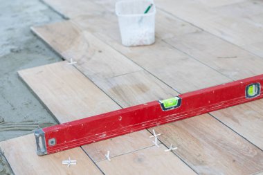 Bahçe terasında çimento, döşeme, bina ve kaldırım kavramının üzerine modern seramik fayanslar döşeyen profesyonellerin elleri.