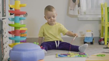 Eğitici bir balıkçılık oyuncağıyla oynayan sevimli küçük çocuk, evde motor becerilerini geliştiriyor.