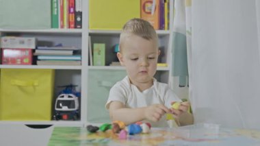 Renkli model kil ile oynayan tatlı çocuk, ev konseptinde yaratıcılık.