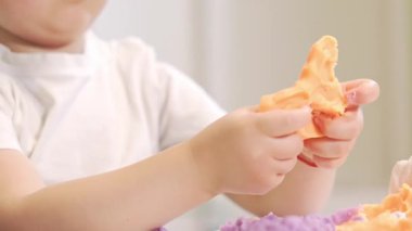 Küçük çocuk renkli plastik kalıplar yaparak ve şekil vererek iyi motor becerileri geliştiriyor.