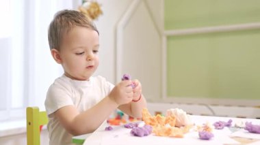 Çamurla oynayan ve evdeki motor becerilerini geliştiren tatlı bir çocuk.