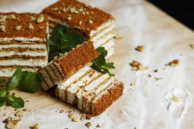 Nane ve siyah arka plan üzerine bir ahşap tahta üzerinde fındık ile bal pasta