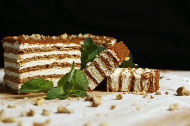 Nane ve siyah arka plan üzerine bir ahşap tahta üzerinde fındık ile bal pasta