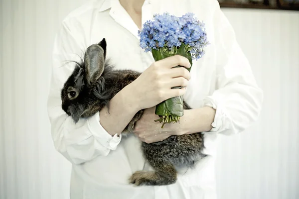 Girl with flowers holding rabbit