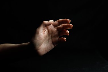 Siyah arka plan üzerine eller hareketleri gösterir