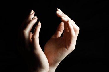 Siyah arka plan üzerine eller hareketleri gösterir