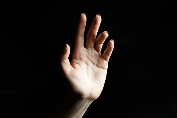 Mãos femininas em fundo preto mostra gestos — Fotografia de Stock