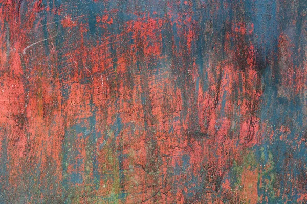 Old metal sheet with remnants of paint in different colors - red, blue, green. Background. Texture.