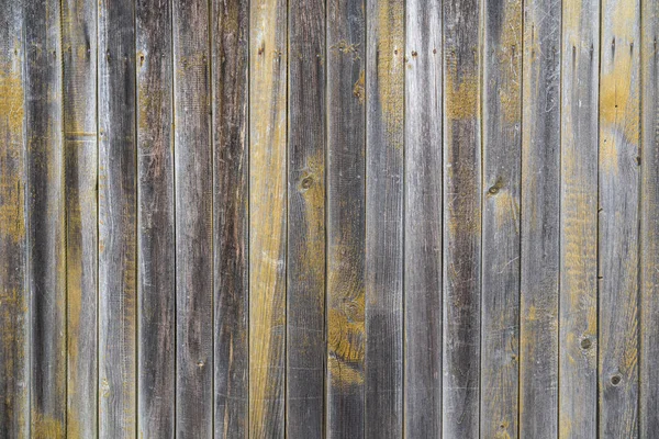 用灰色的旧木板砌成的木墙 粗糙木材表面的黄色油漆残留物 — 图库照片