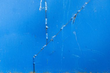 Mavi metal yüzey çeşitli şekillerin üç parçasından oluşur. Kaynak izleri ve biraz da aşınma izleri var. Geçmişi. Doku. 