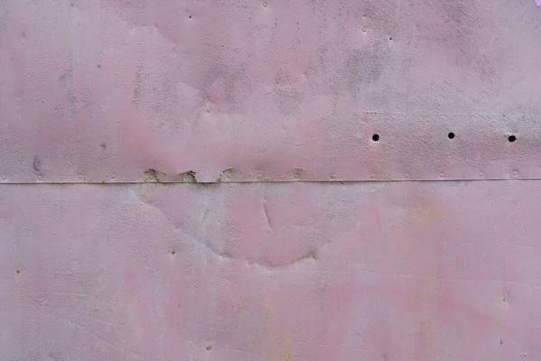 一堵被旧铁皮覆盖的墙的特写 有两片敲打的痕迹 腐蚀的痕迹和钉子上的孔 表面涂满了紫色油漆 — 图库照片