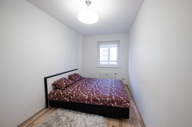 Rahat ve minimalist bir yatak odası. Zarif bir yatak odası, parlak bir duvar rengi ve pencereden gelen doğal bir ışık.