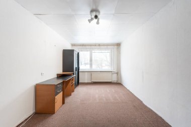 Terk Edilmiş Minimum Mobilyalı ve Büyük Pencereli Geniş Ofis Odası. İç mekan. Beyaz Duvarlar. Oda boş ve çok sade bir görünüme sahip. Sovyet Tarzı