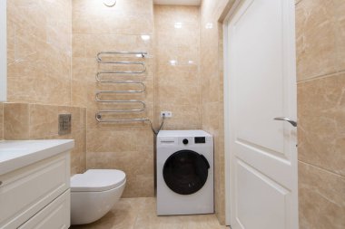 Zarif modern banyo bej kaplama duvarlar, parlak beyaz bir gösteriş, ve rahat bir küvet, lüks, temiz ve çağdaş bir ev tasarımı için ideal.