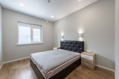 Konforlu bir yatak odası, şık bir ışıklandırma ve şık mobilyalar, parlak ve davetkar bir yer yaratıyor.