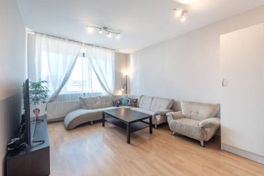 Parlak ve davetkar oturma odası modern mobilyalar, yumuşak doğal ışıklandırma, ve bir kanepe, koltuk ve dekor ile pratik bir düzen