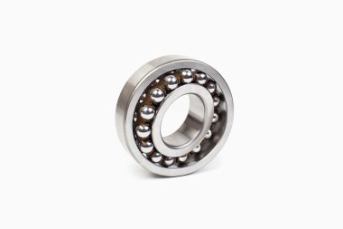 Beyaz arkaplanda mekaniğin yedek parçası olan yakın çekim yatakları.