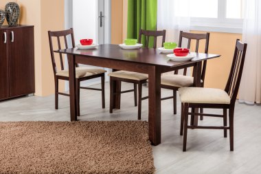 Simple wooden dinning table and chairs in interior - studio ambi clipart