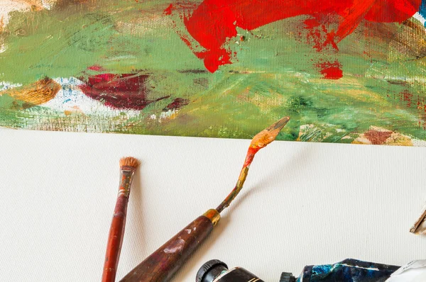 Brosse à peindre et couteau à palette sur un bureau en toile vierge — Photo