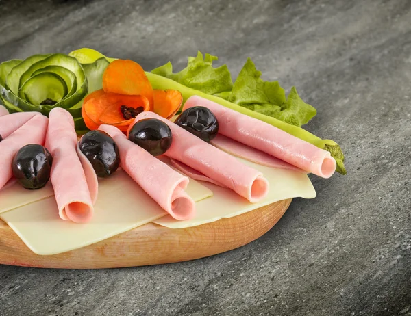 Sliced ham salami dihias di papan kayu dengan zaitun, tomat dan selada dan jalur kliping — Stok Foto