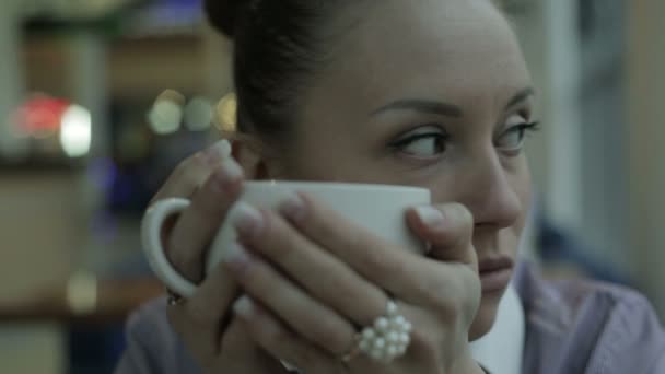 Young woman drinking tea and smiling at camera — Stock Video