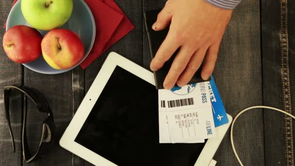 Pass med flygbiljetter på denim bakgrund. grönt äpple på fatet — Stockvideo