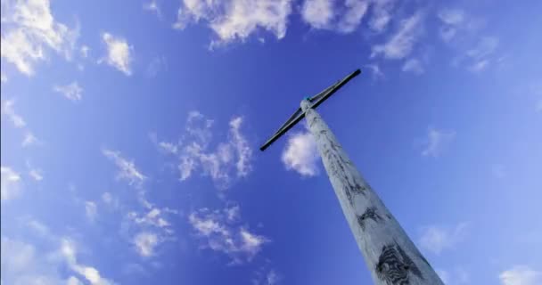 Sinal direcional de madeira no céu azul. Pólo direcional de madeira com uma seta em um céu azul com nuvens voadoras — Vídeo de Stock