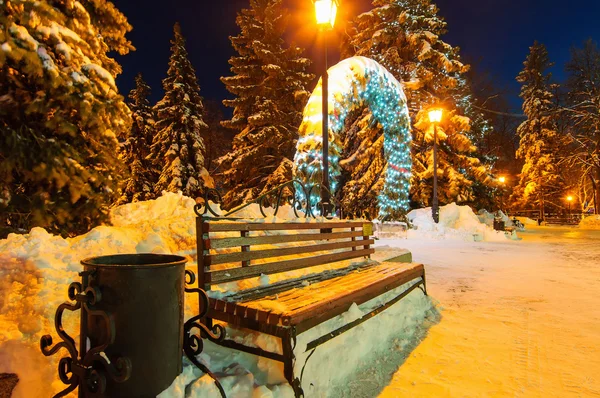 Noční zimní město lavice a vypalování pouliční lampy — Stock fotografie