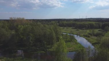 Güneşli bir bahar gününde küçük bir nehrin üzerinden uçmak. 