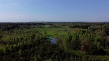 Bir sürü ağaç ve küçük bir nehirle yukarıdan görünen bahar..