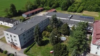 Tarım okulunun eski binalarının üzerinden uçuyor..