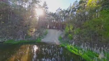 Nehir ve çayır üzerinde alçak ve hızlı bir İHA uçuşu.