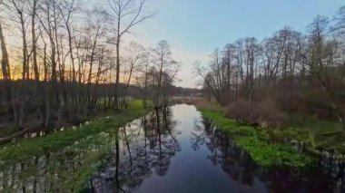 Nehir ve çayır üzerinde alçak ve hızlı bir İHA uçuşu.