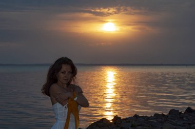 Deniz manzaralı gün batımı plajı ve gökyüzü. Yaz Denizi Sahili Gündoğumu. Romantik gün batımı ufkunda bir kız. Siluet kız gündoğumu. Yazın gün batımında deniz sahilinde romantik bir kadın. Denizde bir kadın gün doğumunda. Sıcak alacakaranlık.