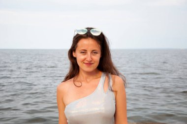 Deniz manzaralı gün batımı plajı. Yaz Denizi Sahili Gündoğumu. Romantik gün batımı ufkunda bir kız. Şık kız gündoğumu. Yazın gün batımında deniz sahilinde romantik genç bir kadın. Denizde kadın gün doğumu.