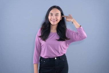 Lavanta gömlekli gülümseyen bir kadın fotoğraf için poz verir.