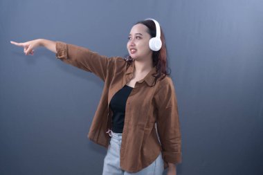 Kahverengi gömlek ve beyaz kulaklık takan bir kadın gülümseyerek gitti.