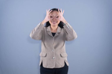 Şef şapkası ve kahverengi önlük takan bir kadın kollarıyla X işareti yapıyor.