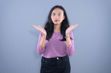 Şef şapkası ve kahverengi önlük takan bir kadın kollarıyla X işareti yapıyor.