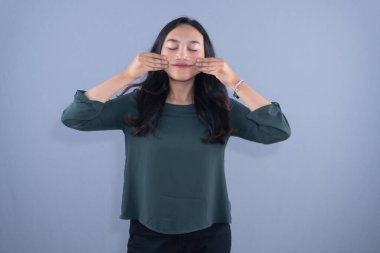 Şef şapkası ve kahverengi önlük takan bir kadın kollarıyla X işareti yapıyor.