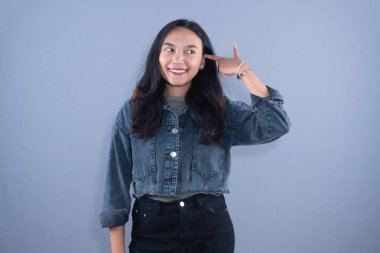 Şef şapkası ve kahverengi önlük takan bir kadın kollarıyla X işareti yapıyor.