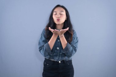 Şef şapkası ve kahverengi önlük takan bir kadın kollarıyla X işareti yapıyor.