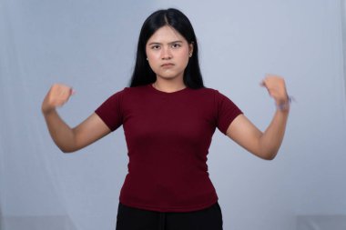 Kestane rengi tişörtlü ciddi bir kadın iki pazısını da esnetiyor.