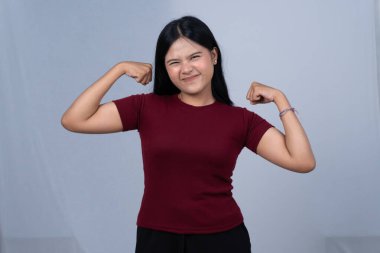 Kestane rengi tişörtlü ciddi bir kadın iki pazısını da esnetiyor.