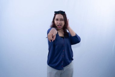 Kafasında gözlük olan genç bir kadın kameraya işaret edip bağırıyor.