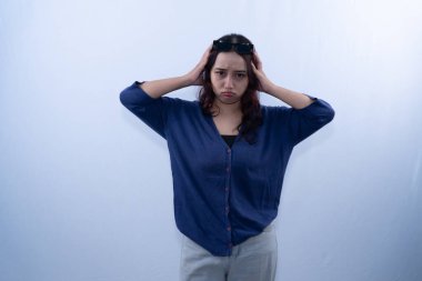 Hüsrana uğramış, başını elinde tutan genç bir kadın.