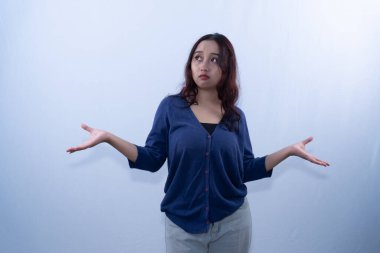 Mavi omuz silkmiş genç bir kadın, şaşkın ya da kararsız görünüyor, açık bir arka plana karşı